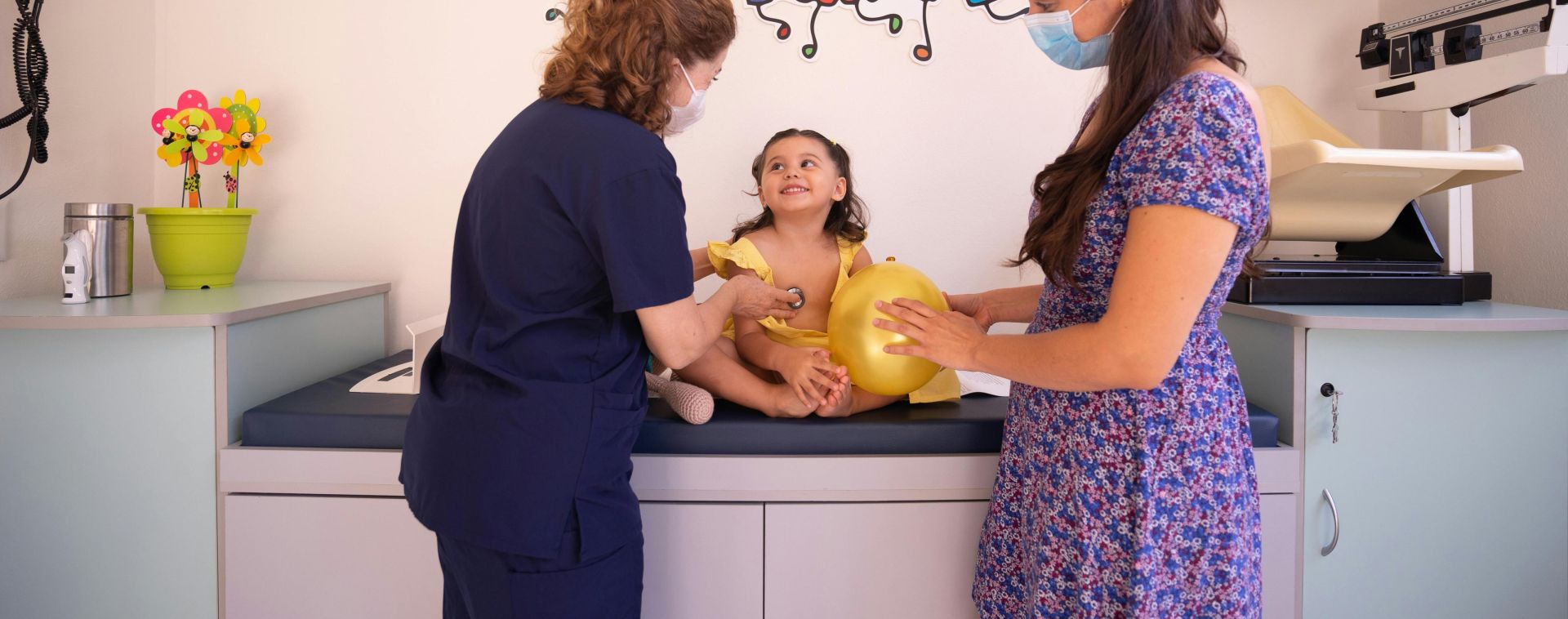 A Pediatrician Checking Up the Baby Girl Sitting on the Bed